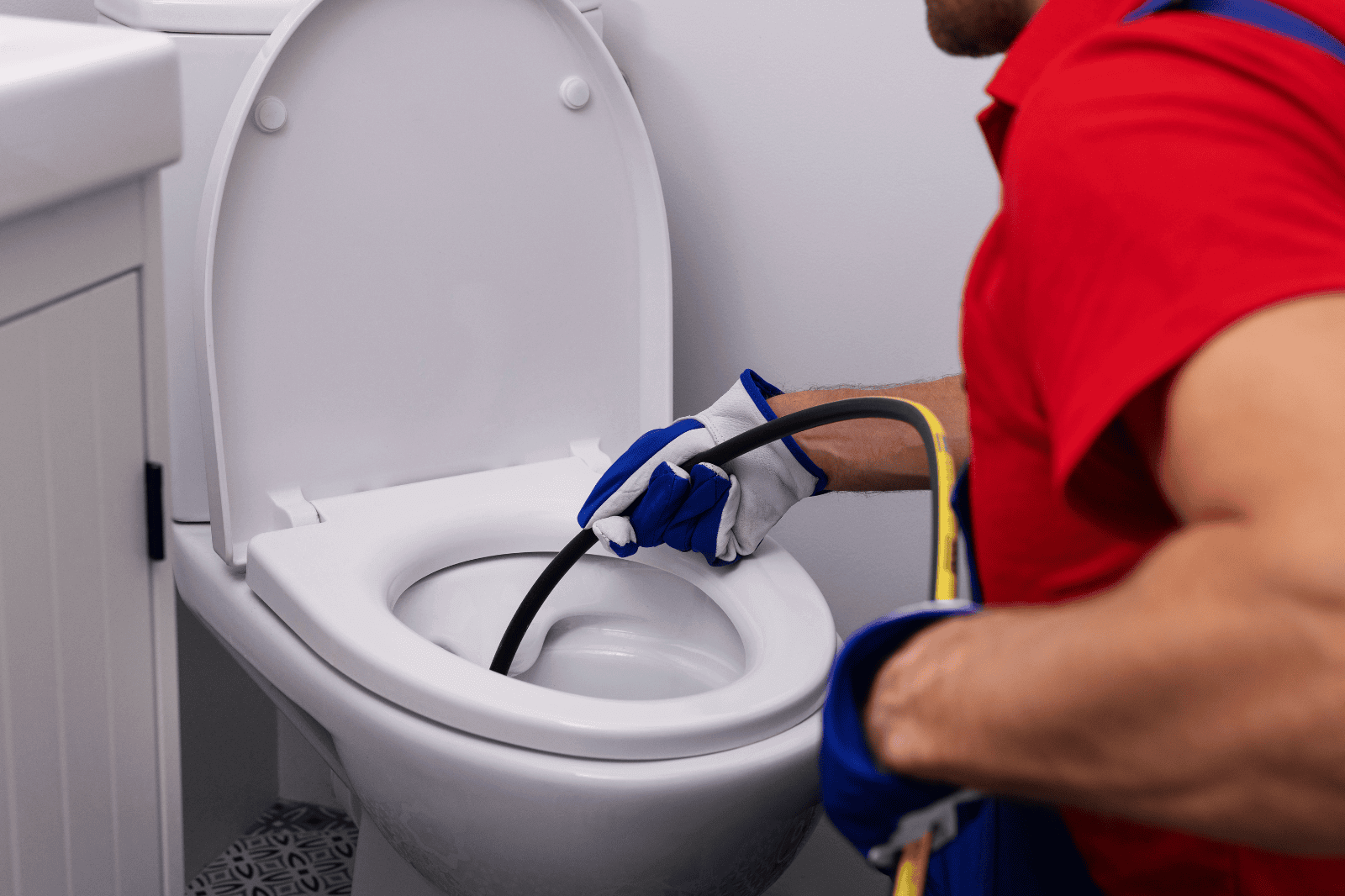 Een man die een toilet aan het ontstoppen is